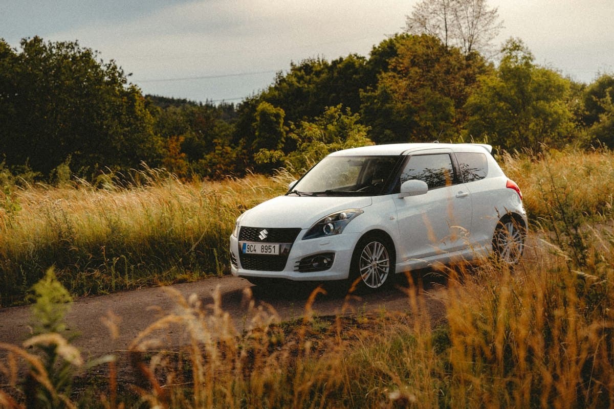 Small white hatchback car parked on a rural road