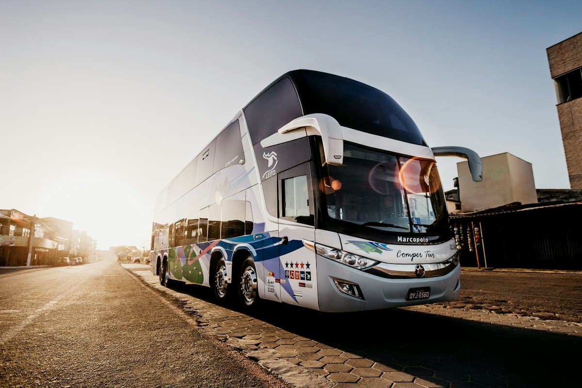 Large double-decker touring coach photographed at golden hour