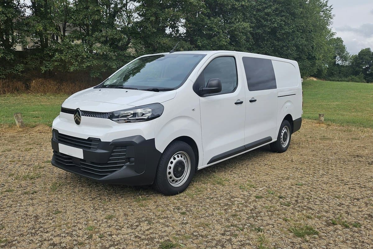 White high-roof van parked on open ground
