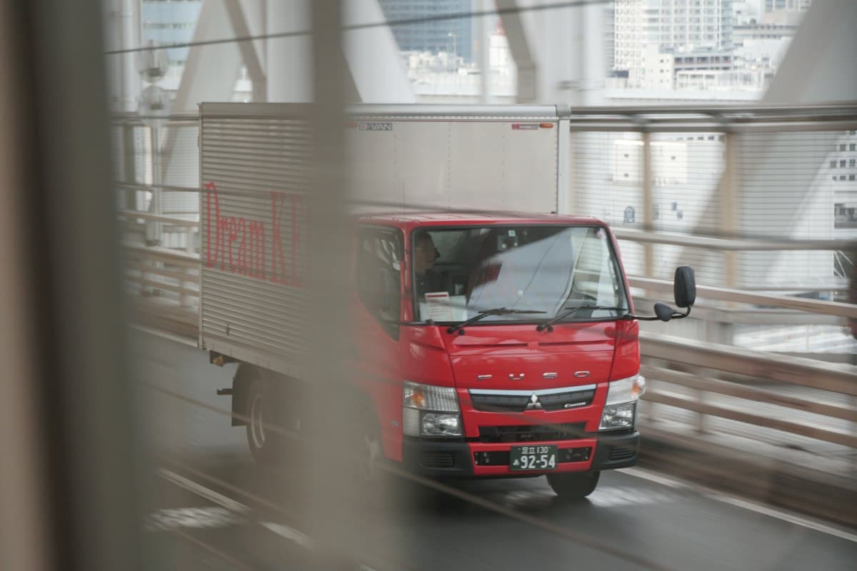 Red box lorry driving on a city road