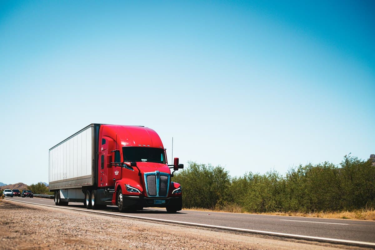 Large red prime mover lorry travelling on an open highway